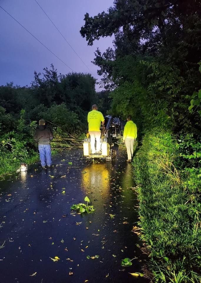 A group of people are walking down a wet road