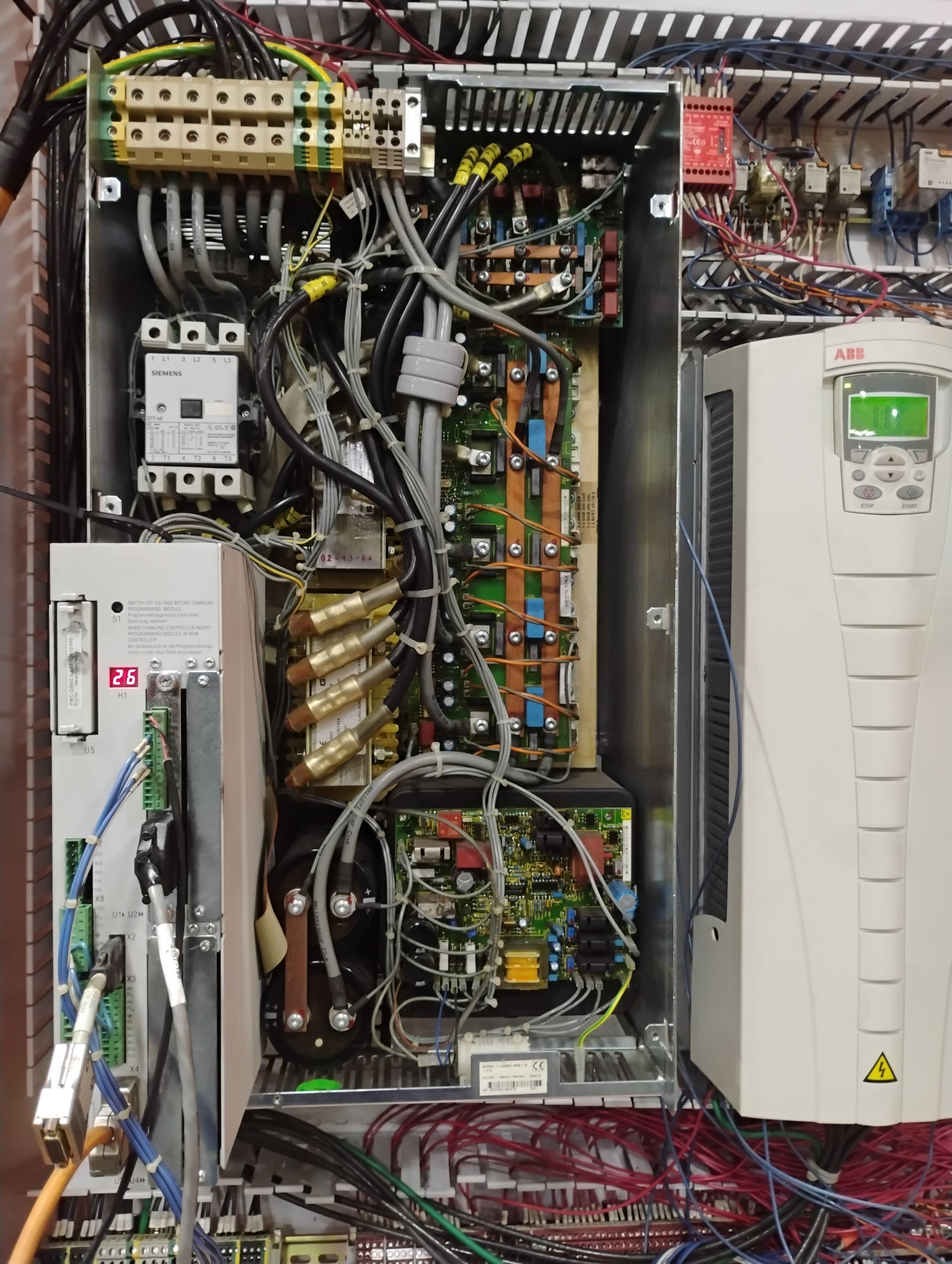 Electrical control panel with wires, components, and a display screen.