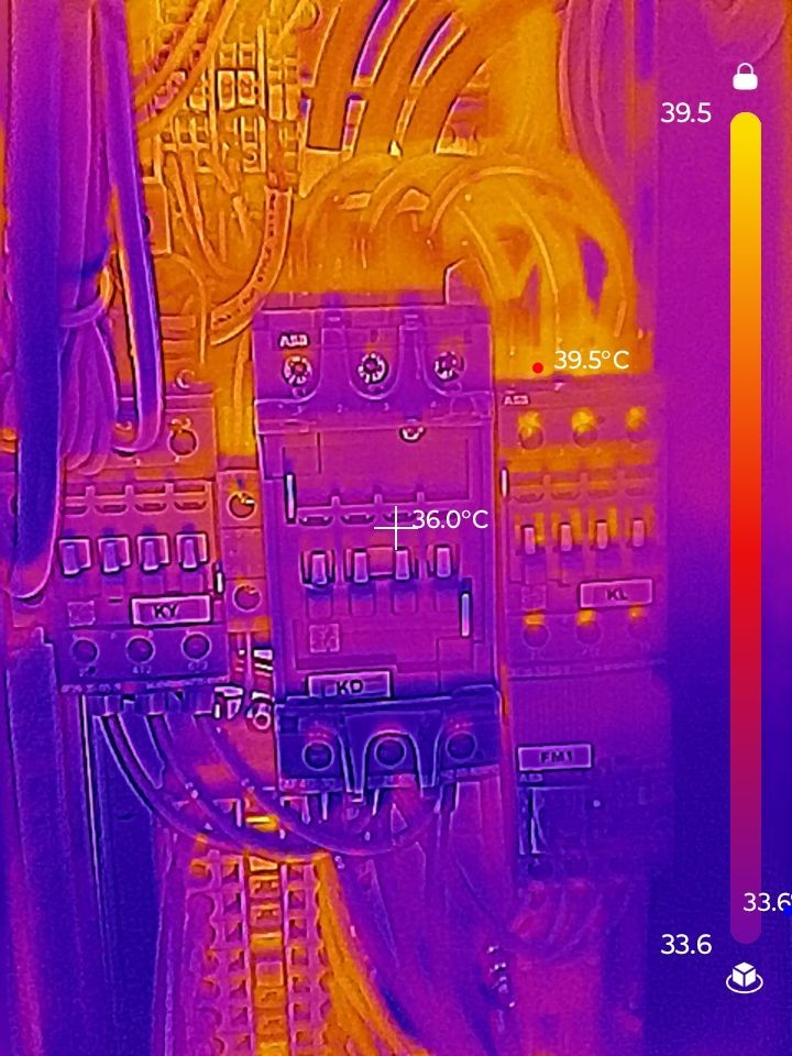 Thermal image of electrical components, with heat signatures shown in yellow and orange. Temperature scale is included.