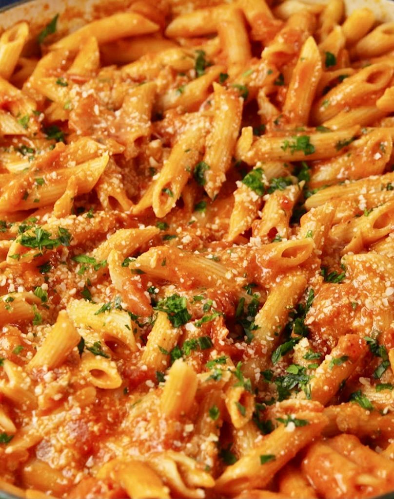 Penne pasta in a creamy tomato sauce, sprinkled with herbs and Parmesan cheese.