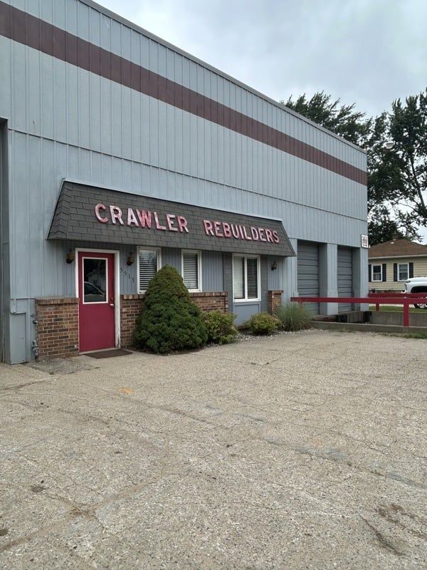 Cranler Reunions storefront with a red door, maroon awning, and gravel parking lot