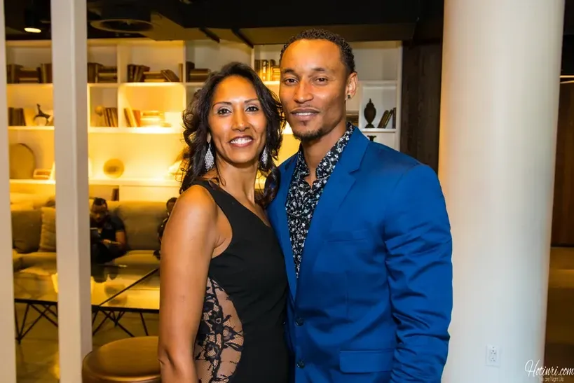 A man in a blue suit and a woman in a black dress are posing for a picture.