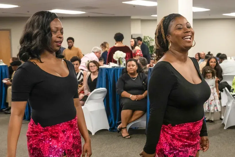 Two women are standing next to each other in a room.
