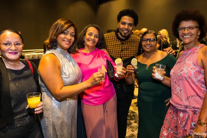 A group of women are standing next to each other holding drinks.