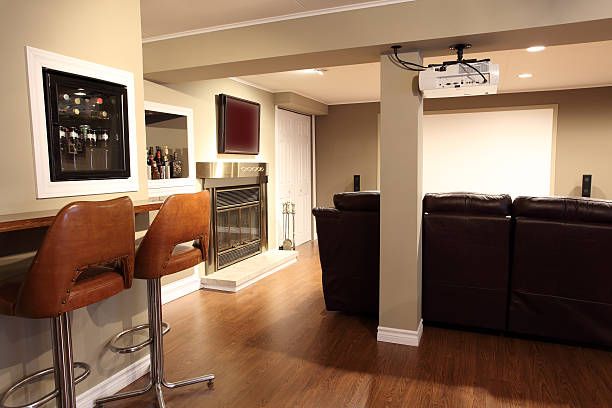 Spokane, WA basement remodel showcasing a custom entertainment space with a built-in wet bar, modern fireplace, and a cozy home theater room.