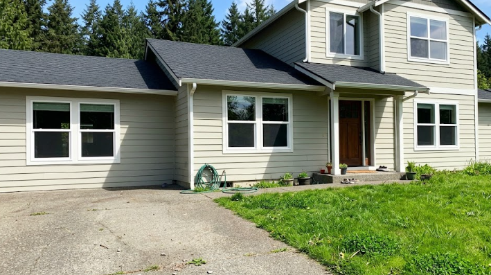 A beautiful house in Spokane WA featuring newly installed, energy-efficient windows and a stylish wooden front door by Spokane General Contractor.