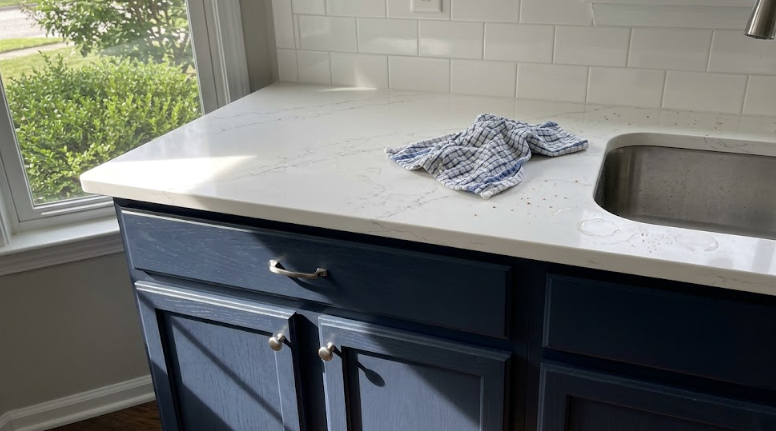 Bright modern kitchen in Spokane featuring white quartz countertops and navy blue cabinets.
