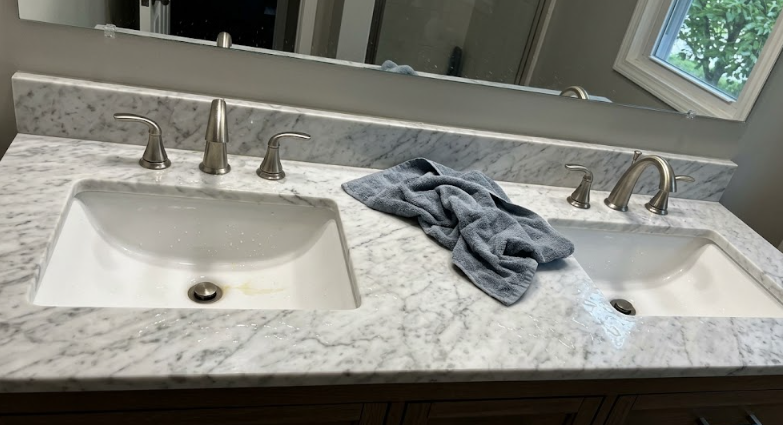 Elegant bathroom vanity featuring custom white marble countertops and double sinks.