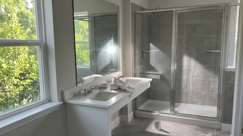 A fully remodeled bathroom featuring a glass walk-in shower and bright modern finishes.