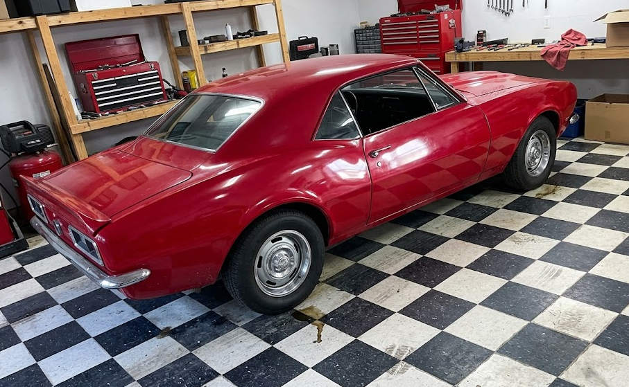 Inside a residential auto mechanic shop featuring a classic car, professional tool cabinets, and upgraded flooring built by a custom shop contractor.