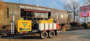 Plumbing service truck parked outside Bayer's Plumbing, Inc. building