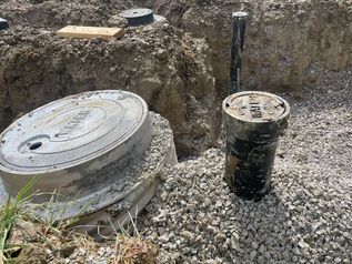 Concrete utility access covers in a gravel excavation site