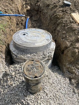 Utility access covers in a gravel trench during construction