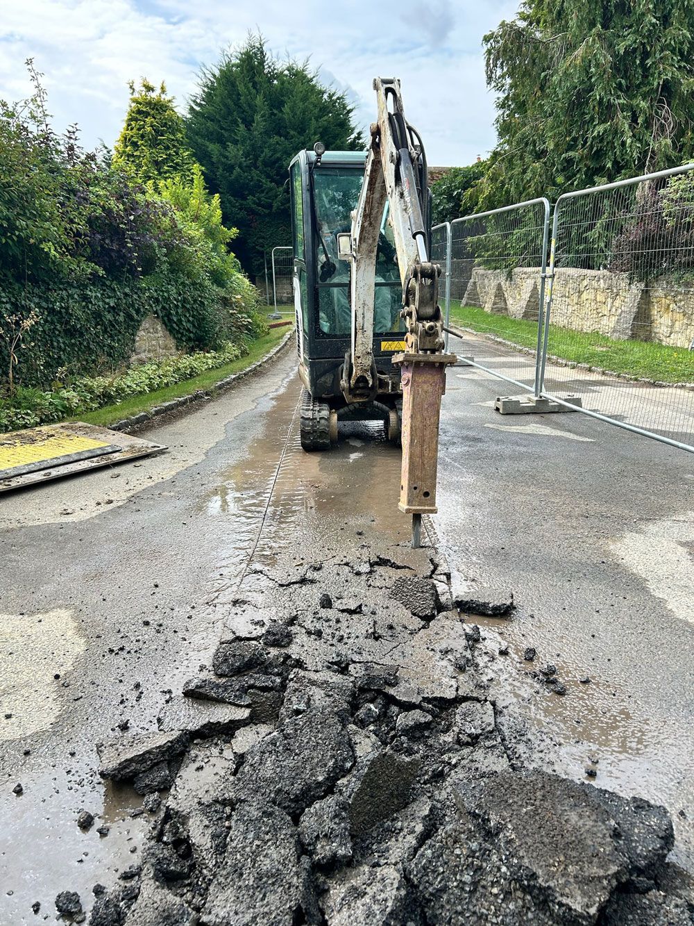 Excavator with breaker attachment working in road