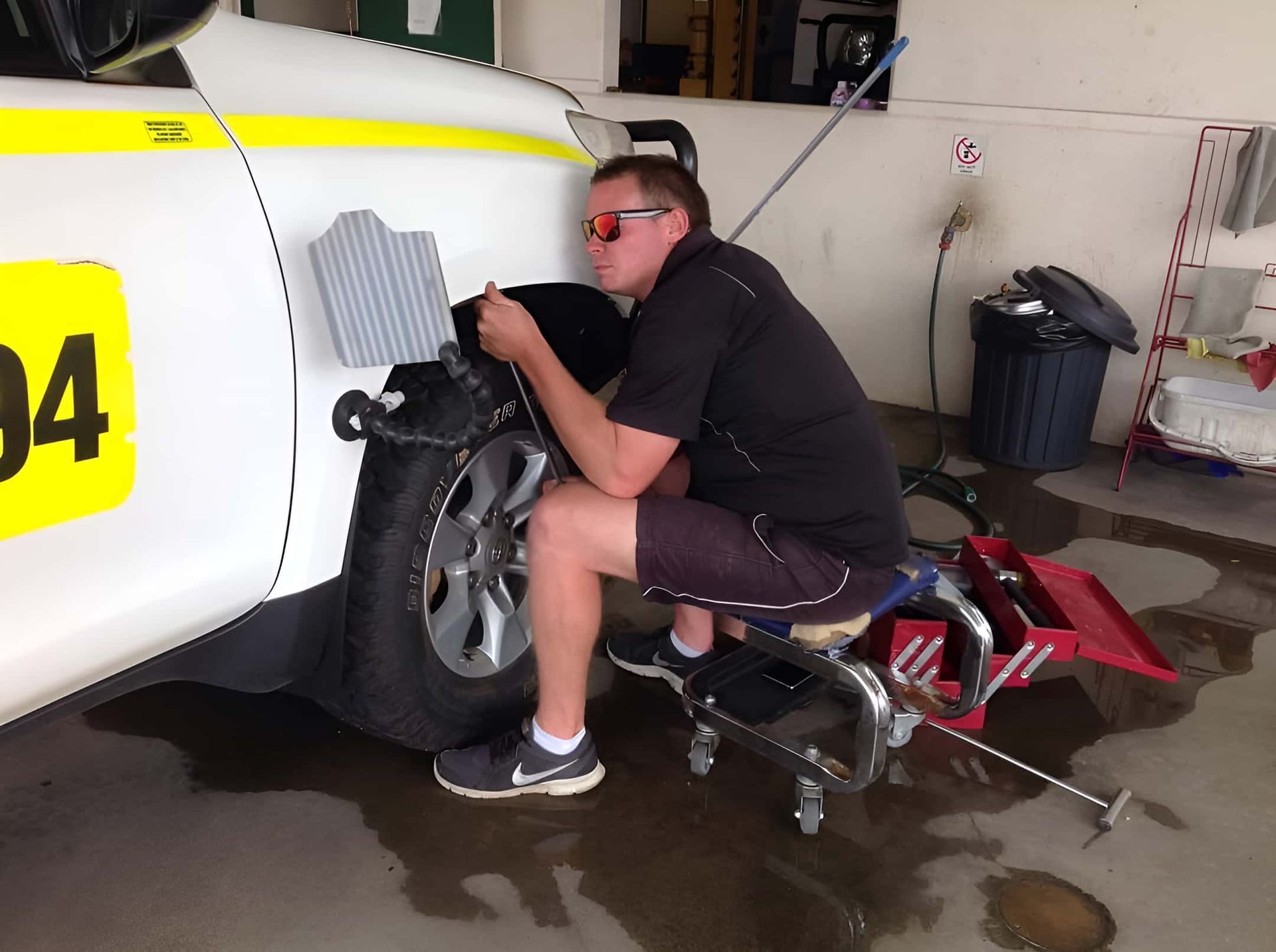 A Man is Working on a Car With the Number 34 on the Side — Dek-A-Dent Townsville In Wulguru, QLD