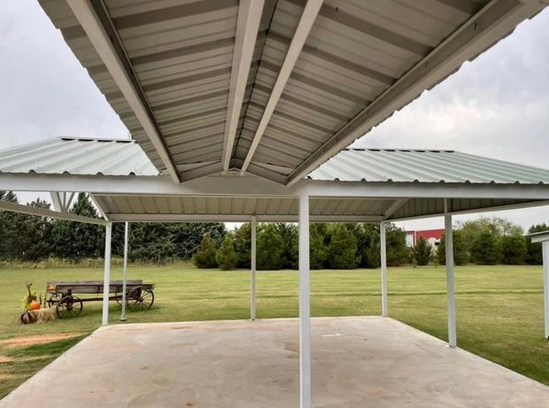 Covered concrete patio with white metal roof overlooking a grassy yard