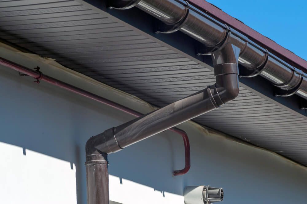 A close up of a brown gutter on the roof of a building.