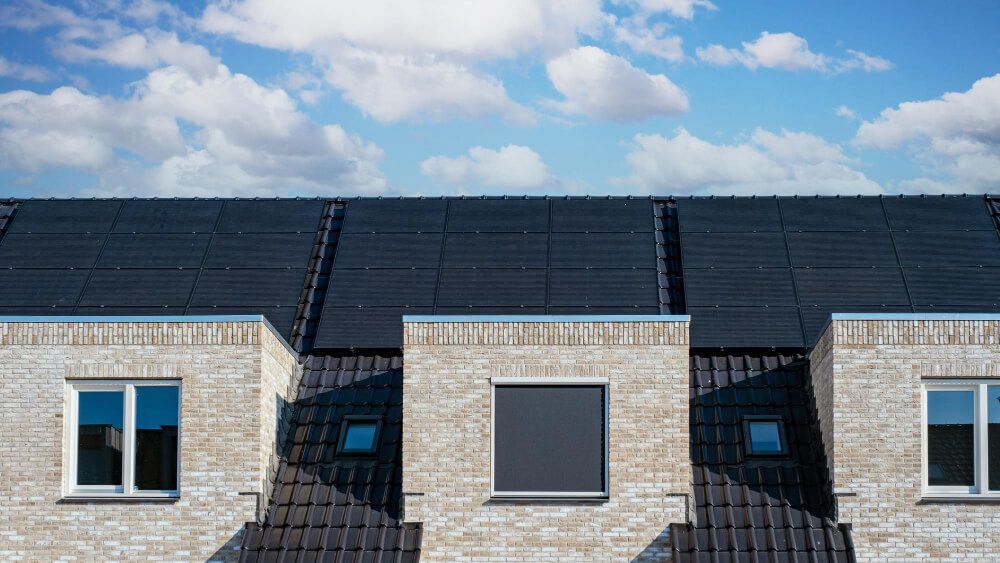 A row of houses with solar panels on the roof.