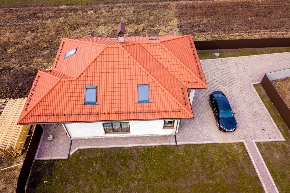 An aerial view of a house with a car parked in front of it.