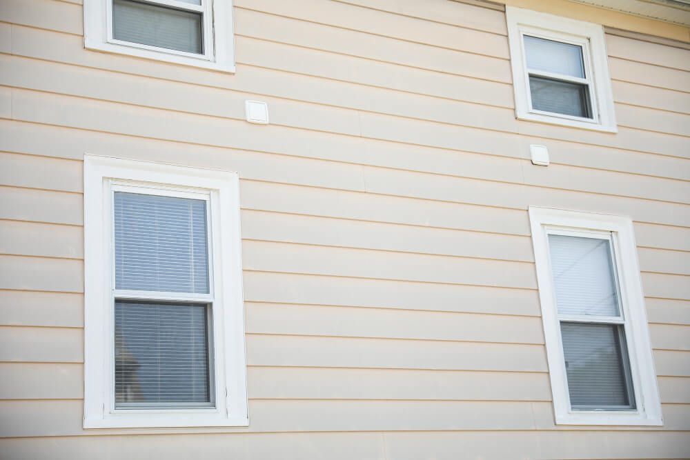 A house with three windows on the side of it.