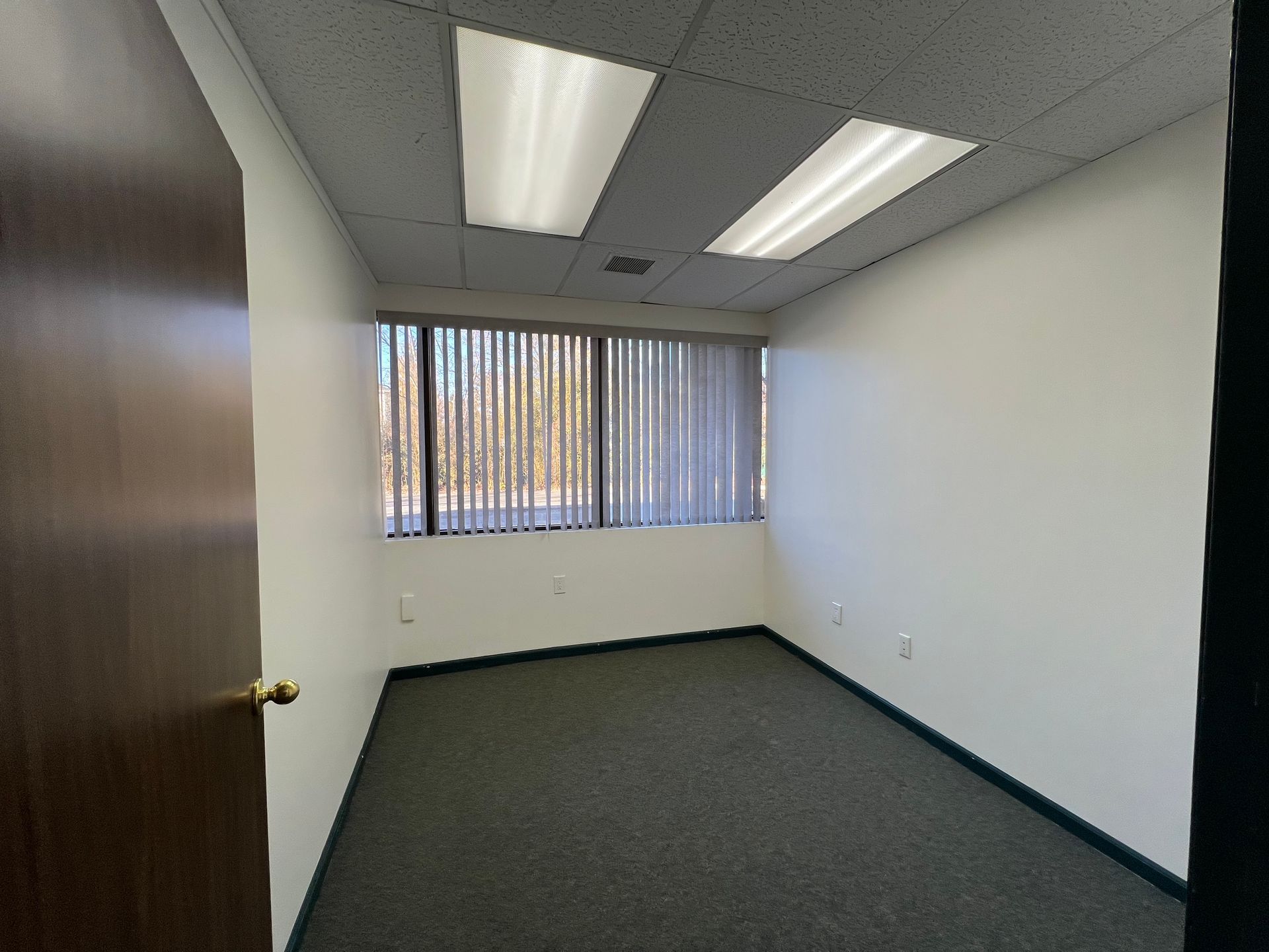 An empty room with a window and blinds