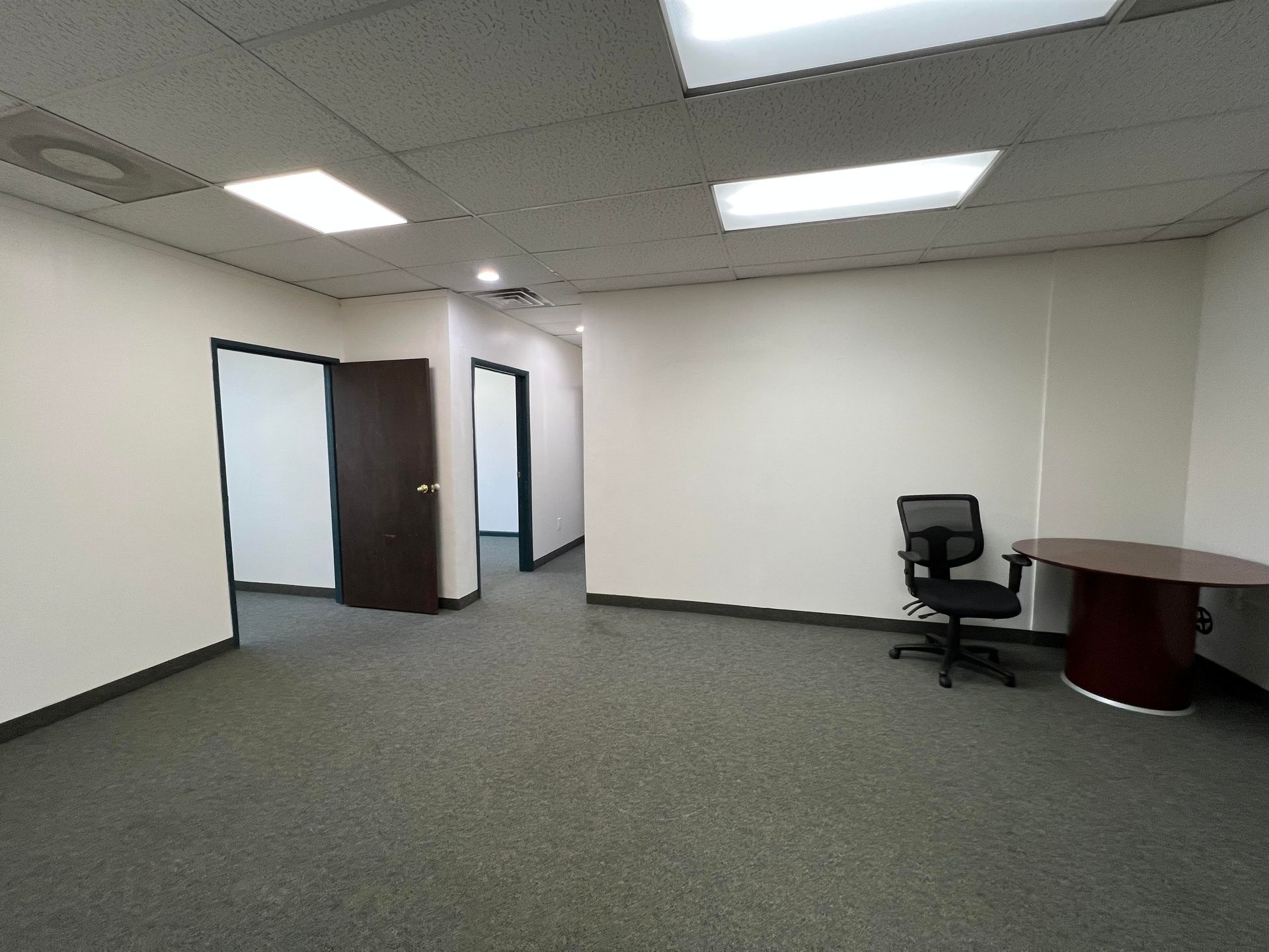 An empty office with a desk and chair in it
