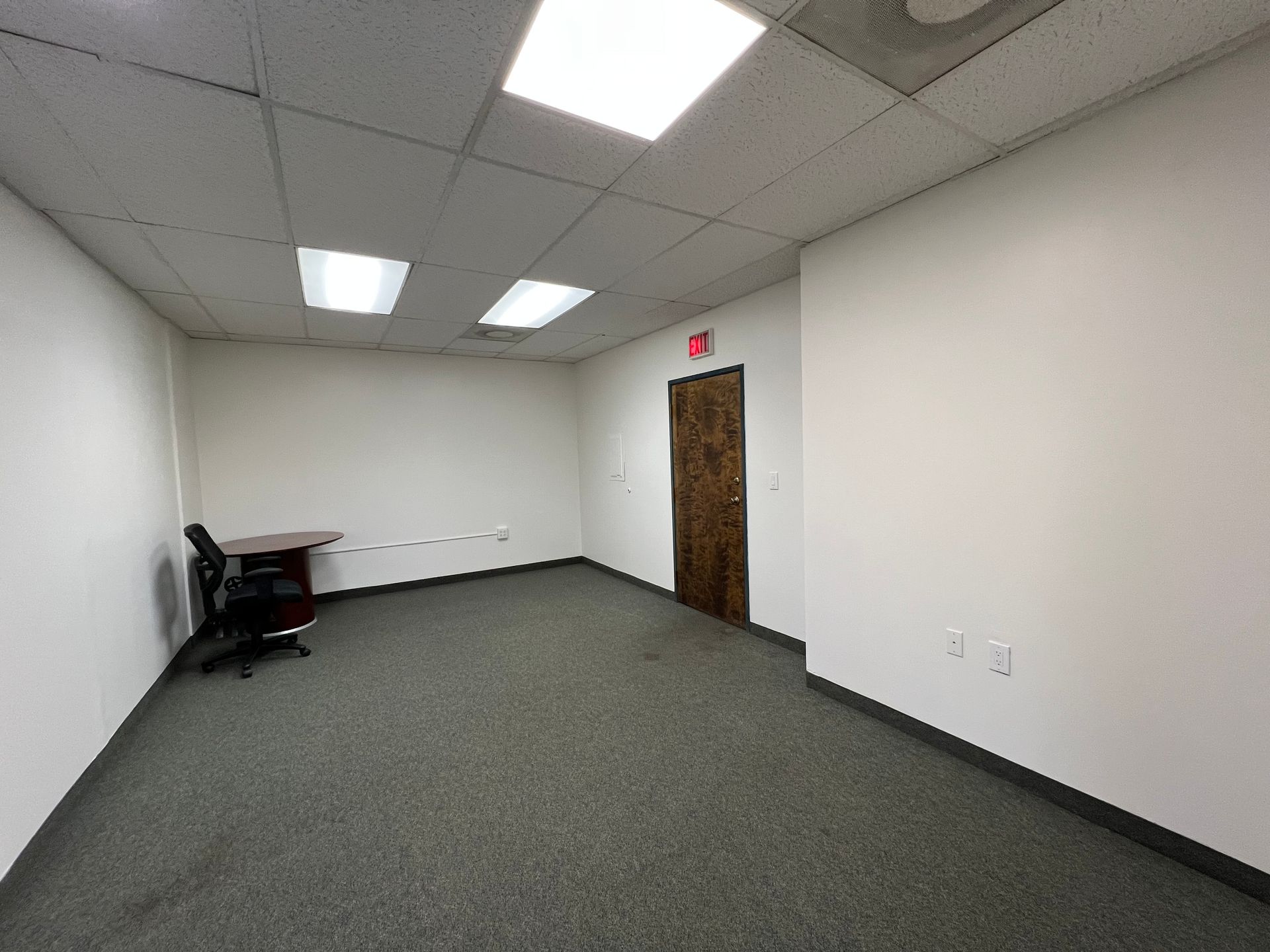 An empty room with a desk and chair in it