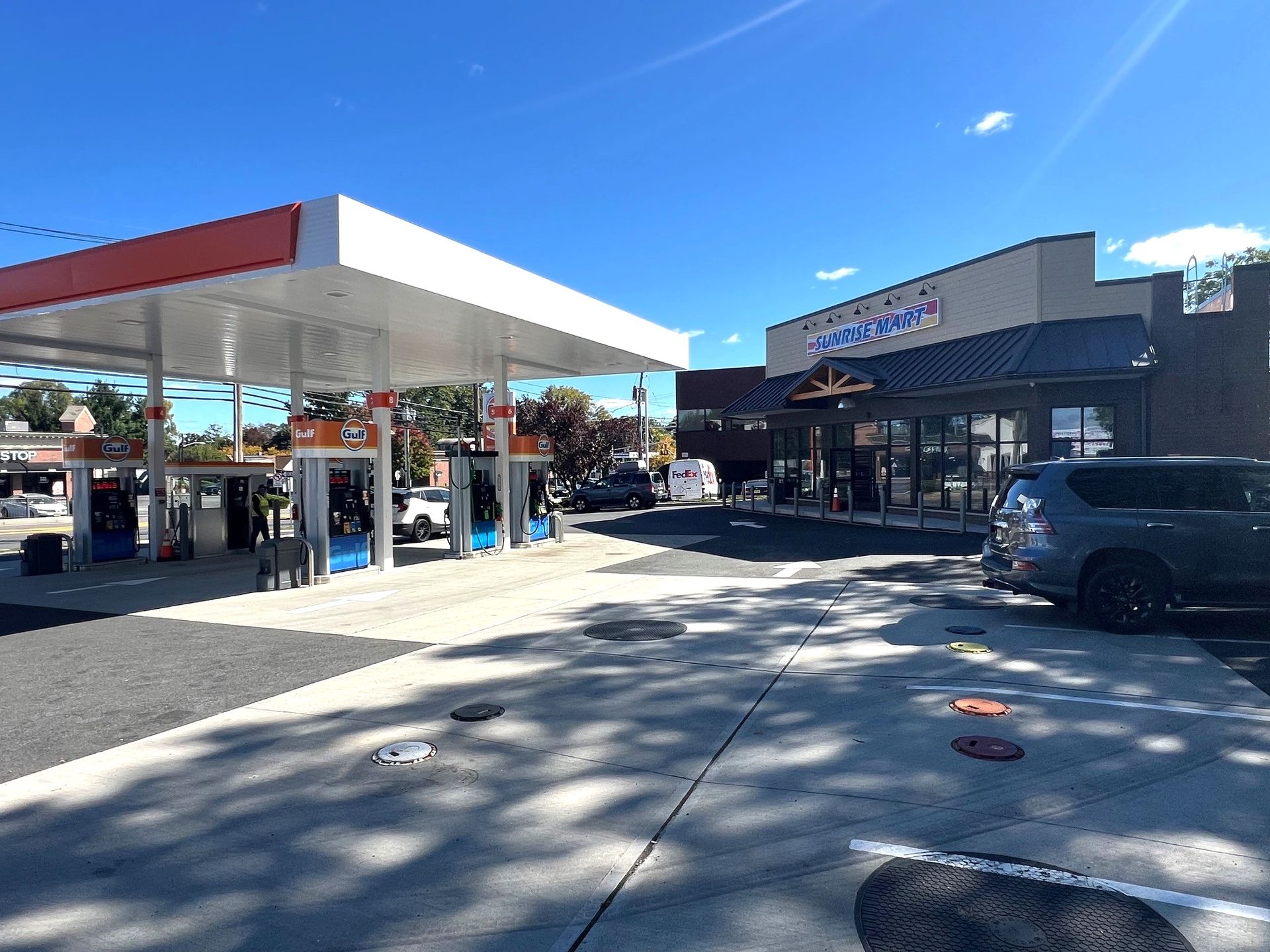 A gas station with a car parked in front of it.