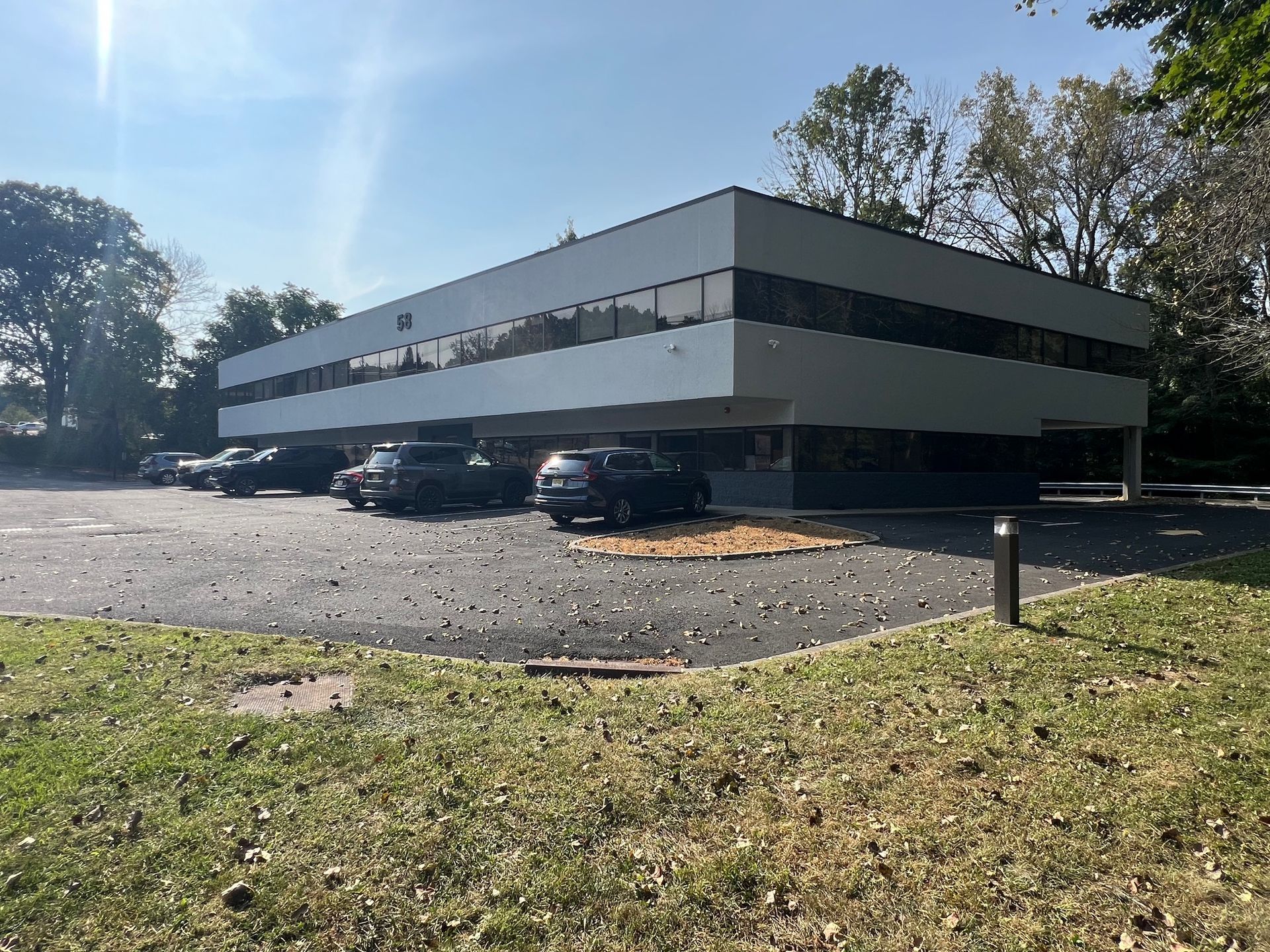 A large white building with cars parked in front of it.