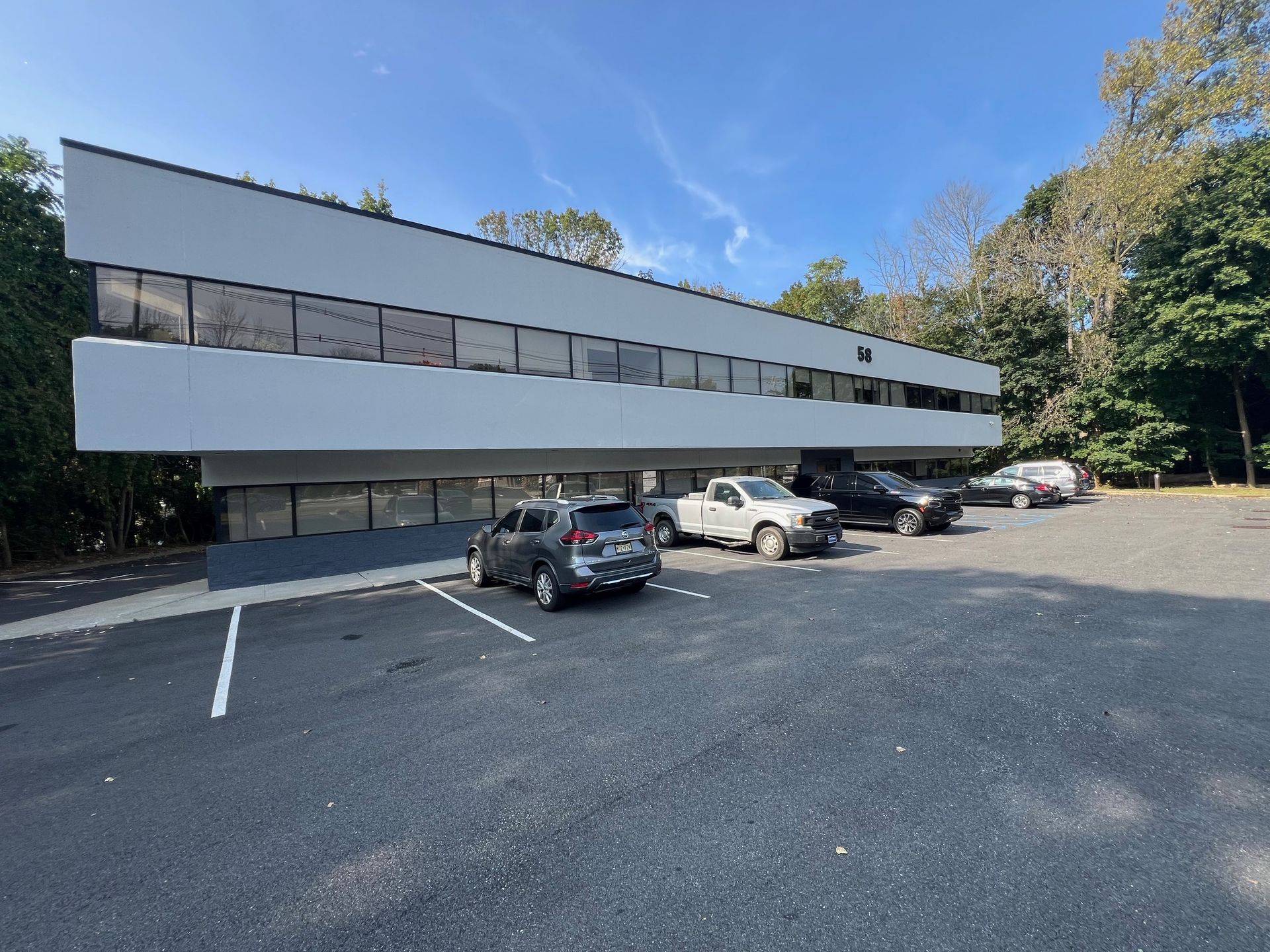 A large white building with cars parked in front of it.