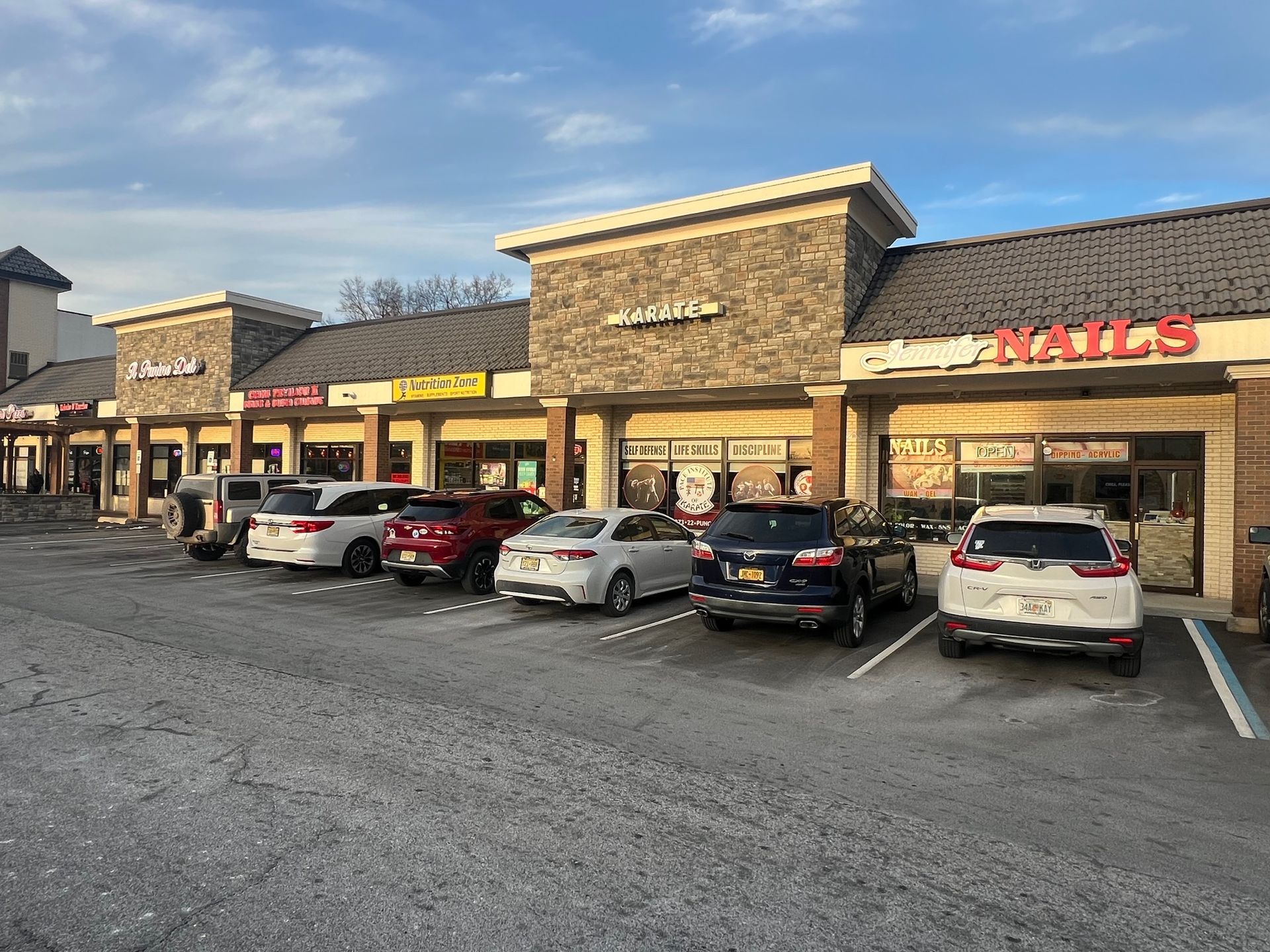 A row of cars are parked in front of a building.