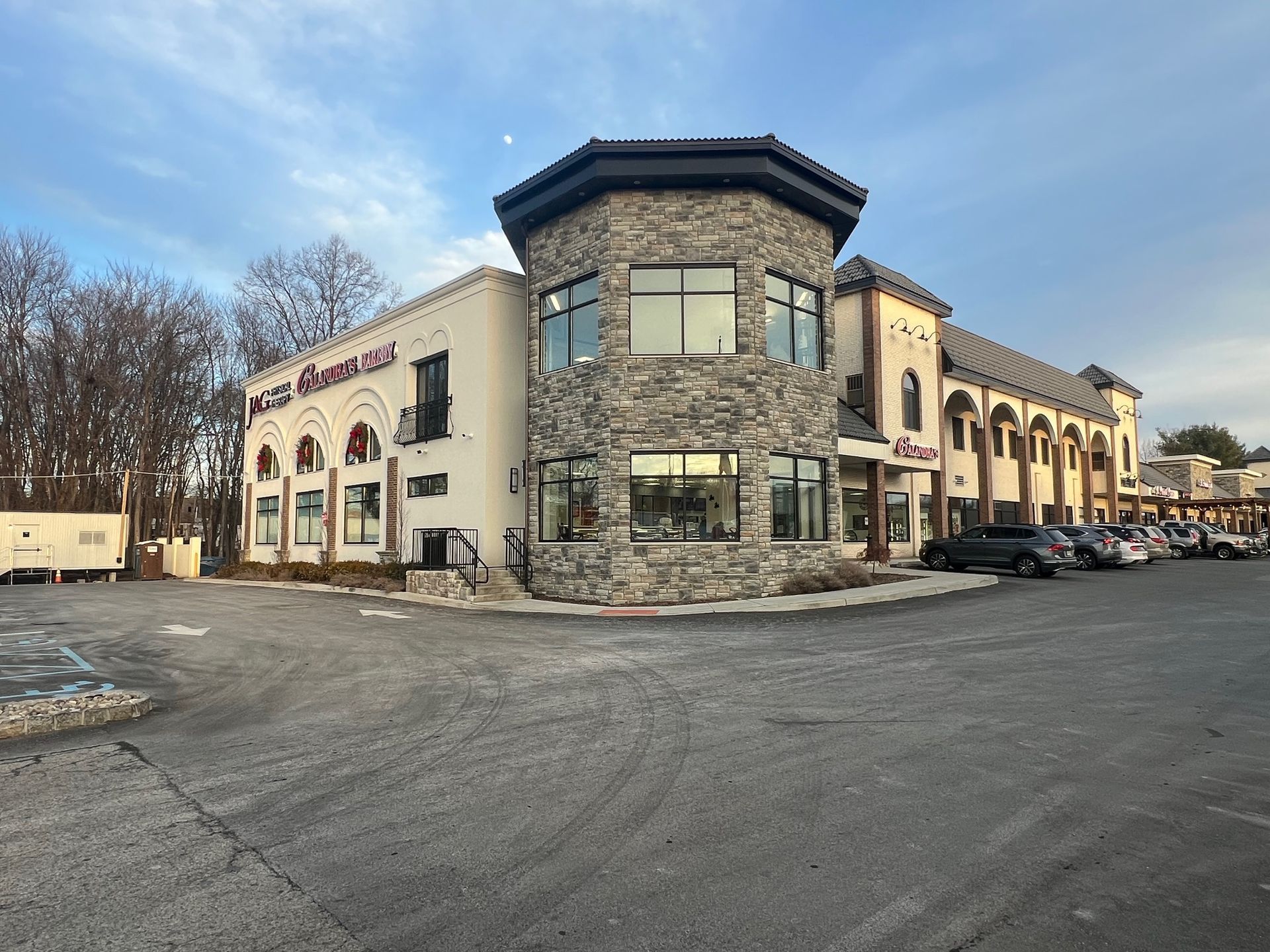A large building with a lot of windows and cars parked in front of it.