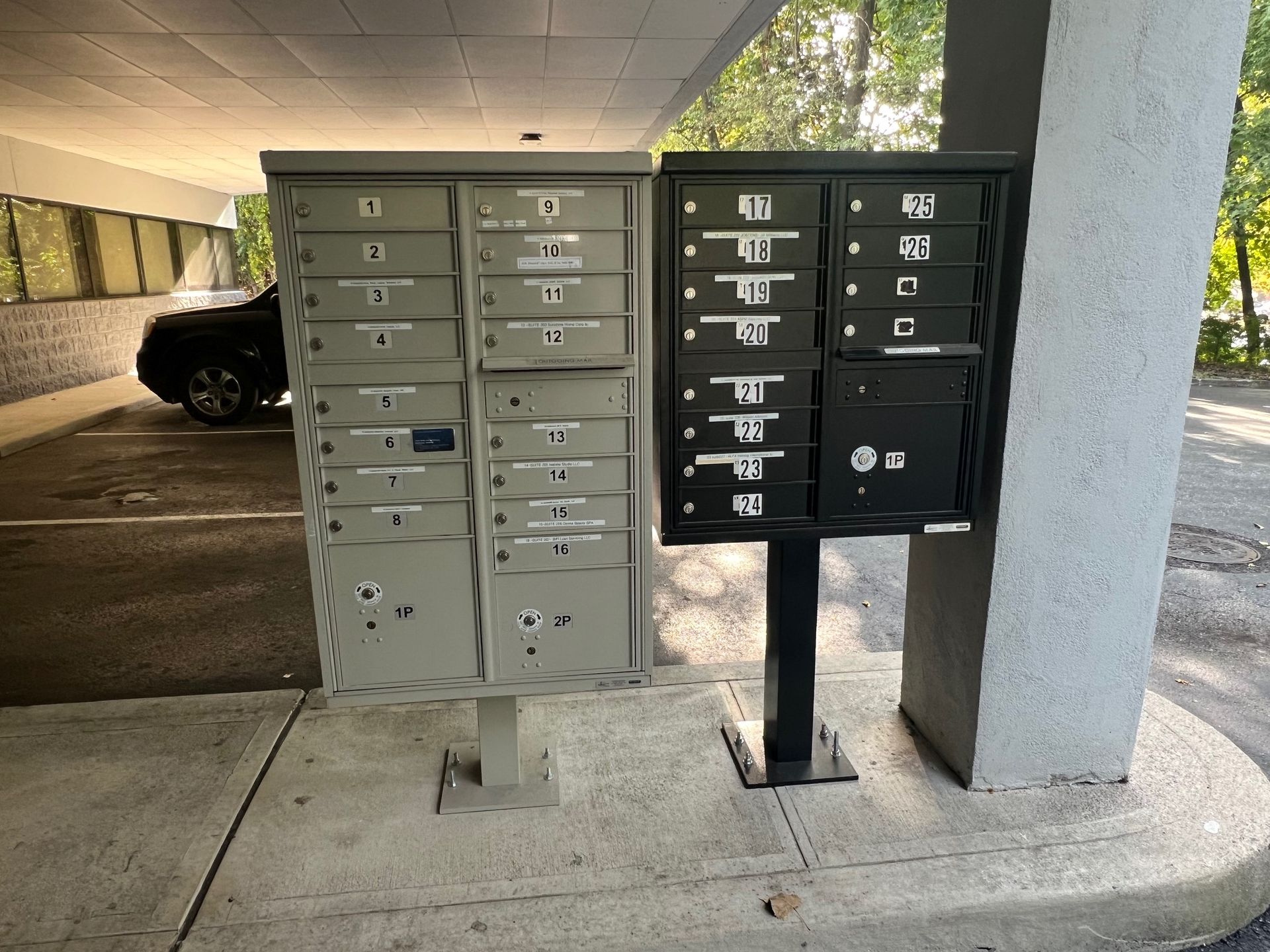 Two mailboxes are sitting next to each other in a parking lot.