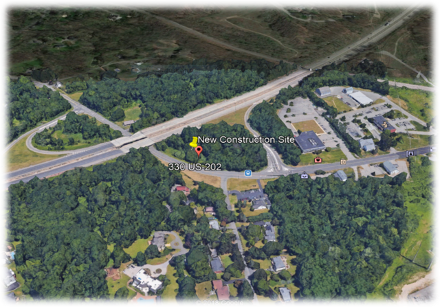 Aerial view of wooded area with highway interchange and businesses nearby, marked with a 