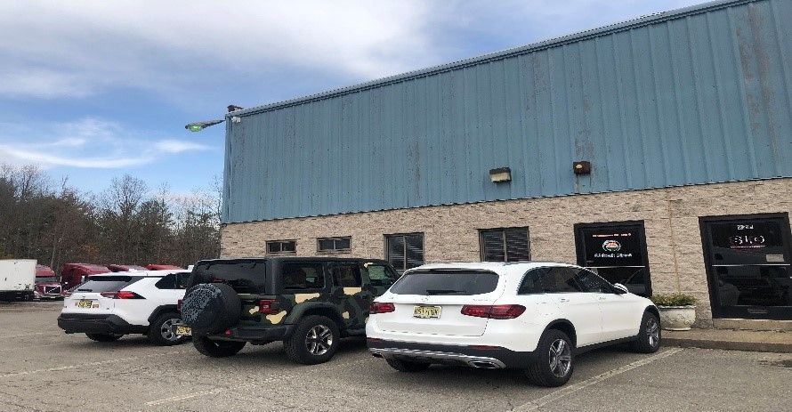 A row of cars are parked in front of a building.