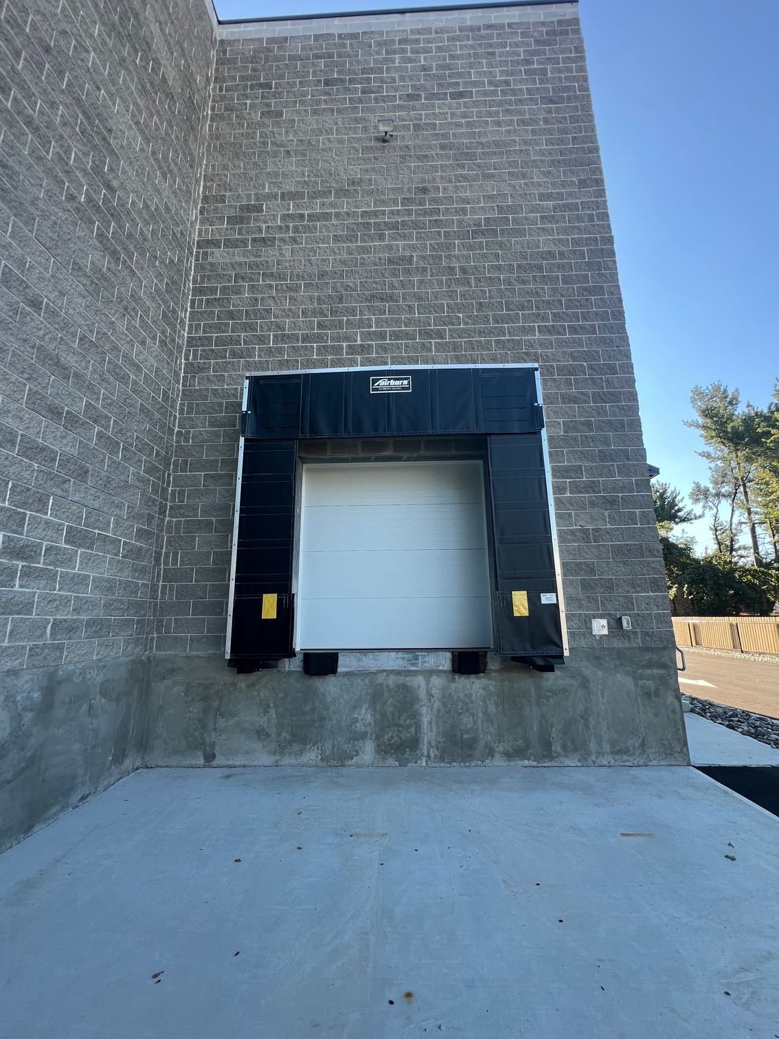 Loading dock door on a brick building with black rubber seals.
