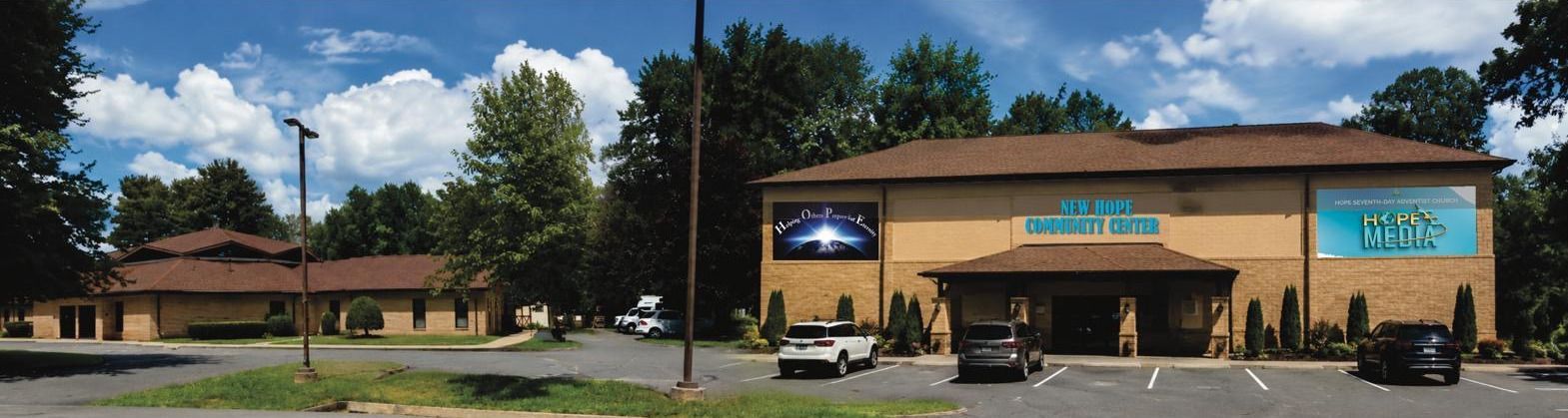 Conceptual rendering of the New Hope Community Center: front elevation of the building with covered entrance and parking.