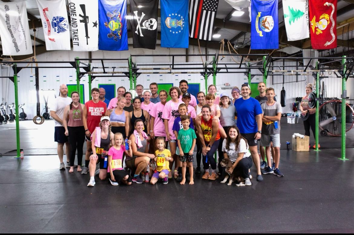 A group of people are posing for a picture in a gym.