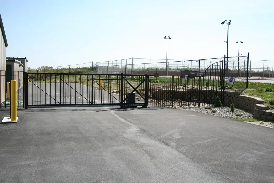 a fence with a gate in the middle of a parking lot