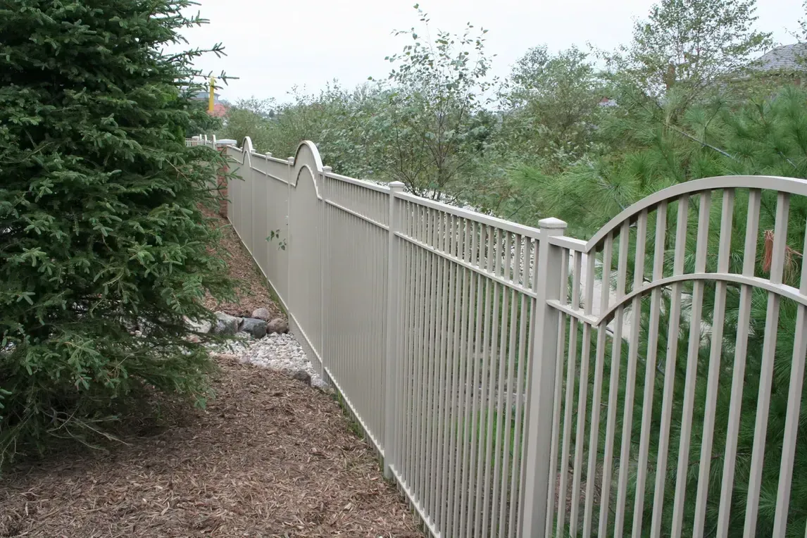 a white metal fence is surrounded by trees