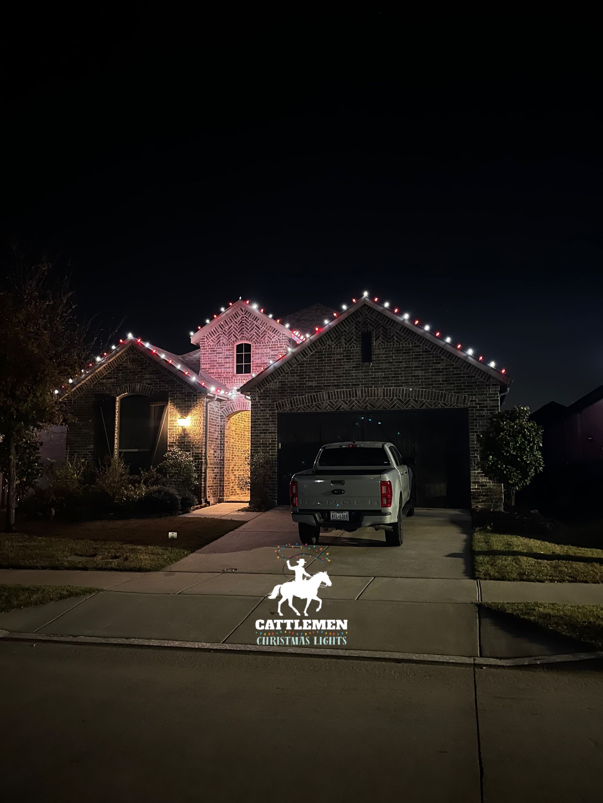 Nighttime suburban house with pink roof lights.