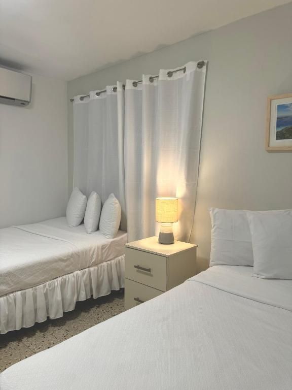 A hotel room with two beds and a nightstand