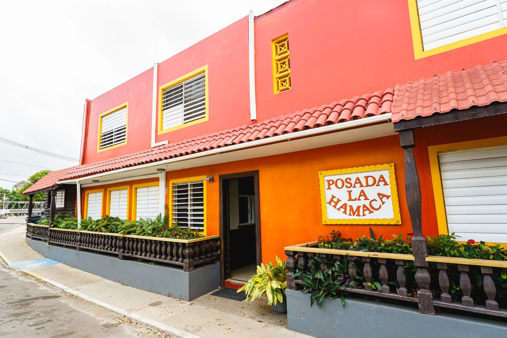 A red building with a sign that says posada la hamaca