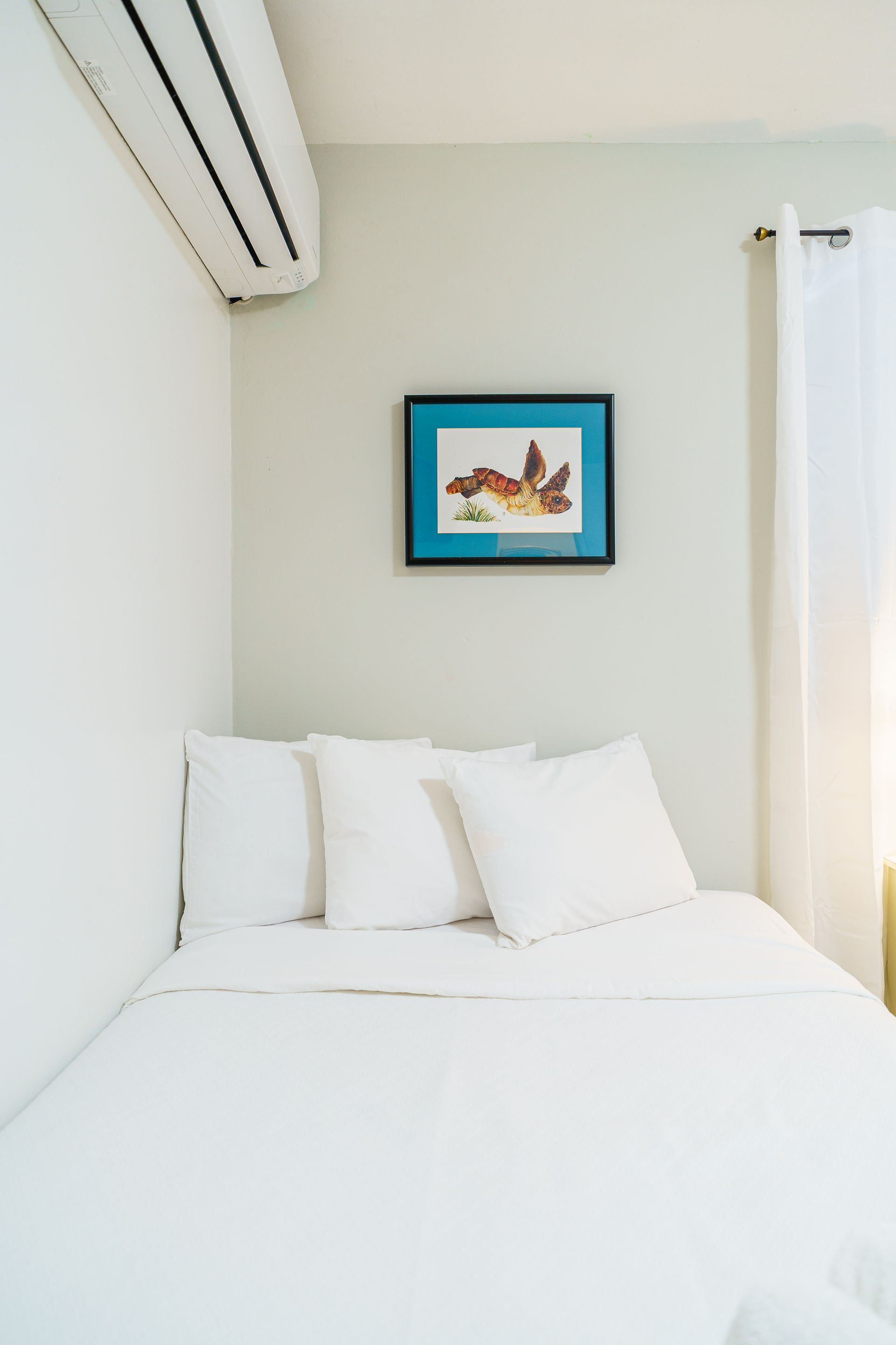 There is a picture on the wall above the bed.