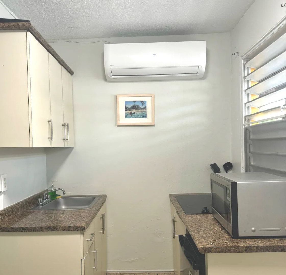A kitchen with a picture on the wall above the sink
