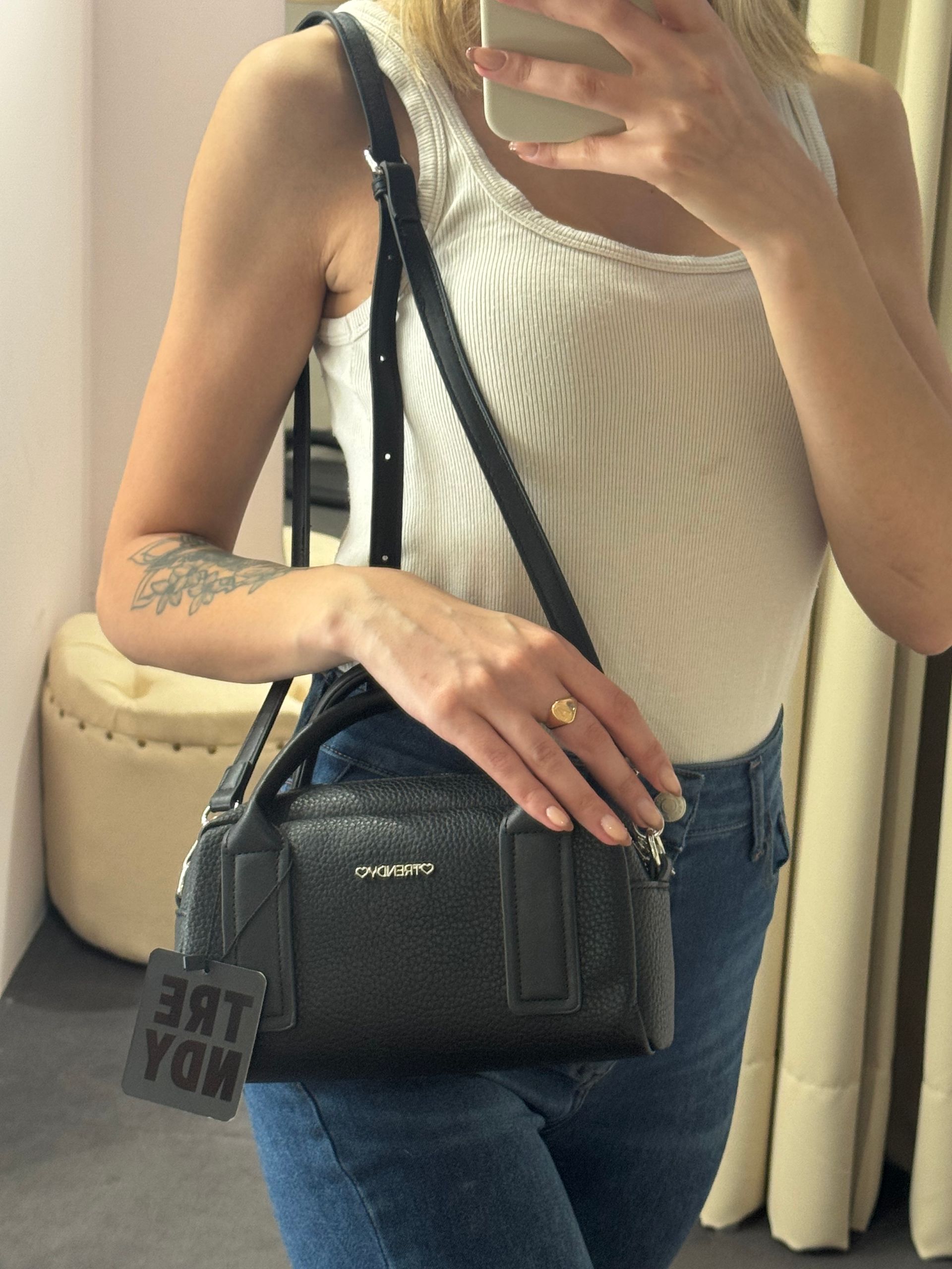 Bolso de mano negro texturizado con una etiqueta que dice 