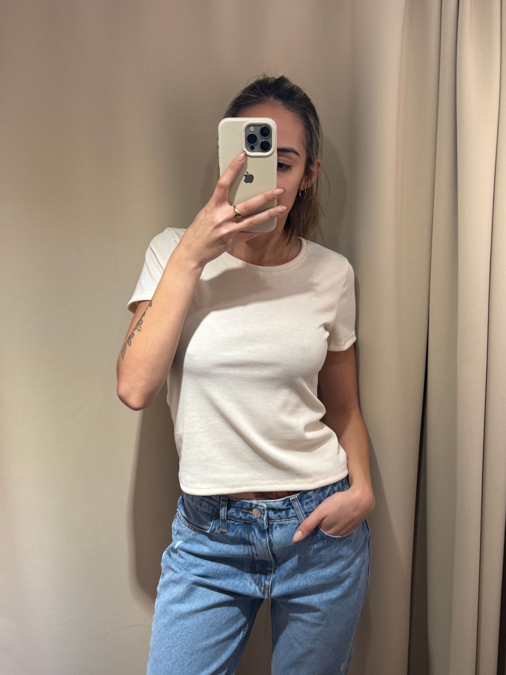 blusa de canalé color crema y jeans azules