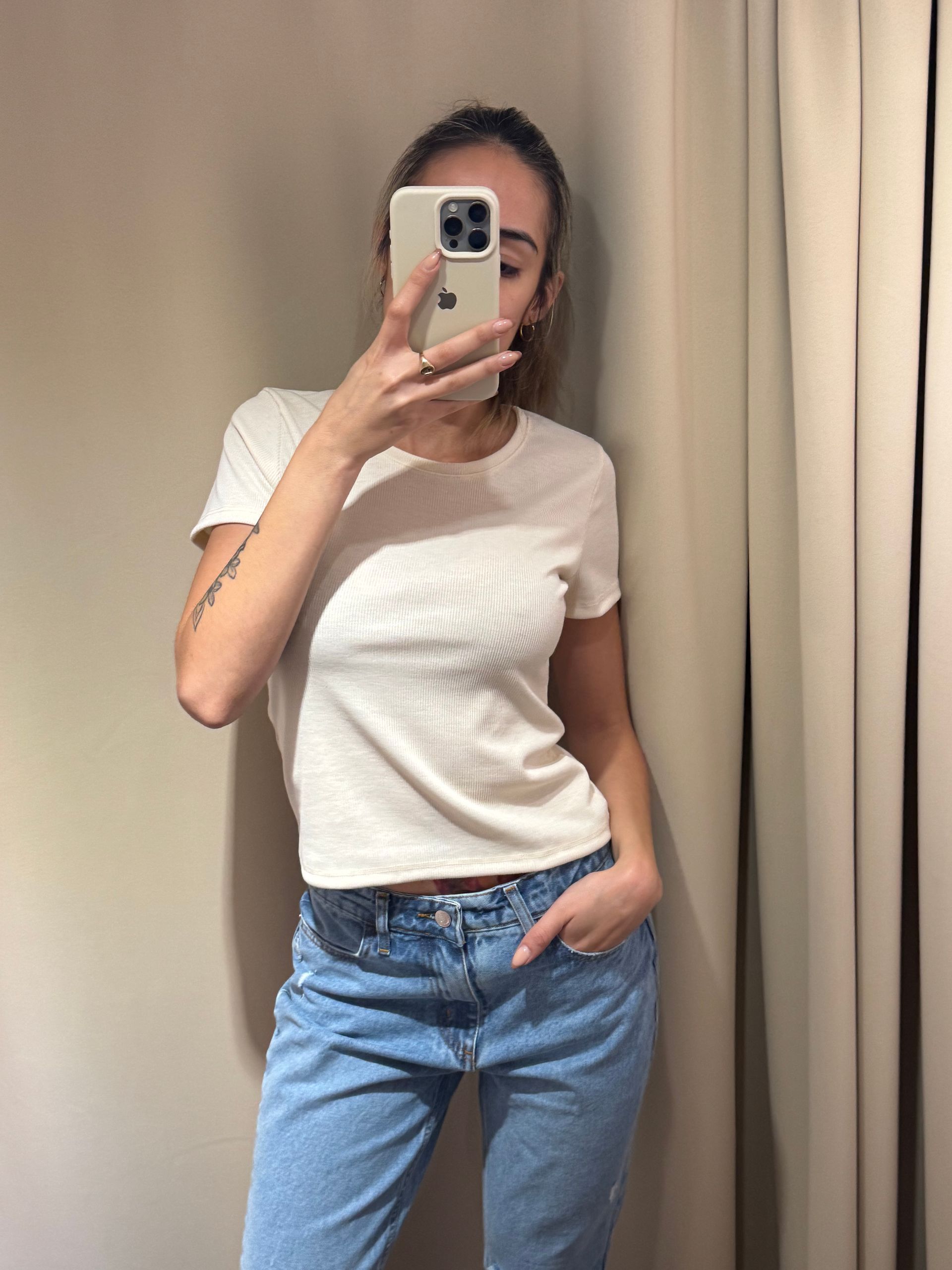 blusa de canalé color crema y jeans azules