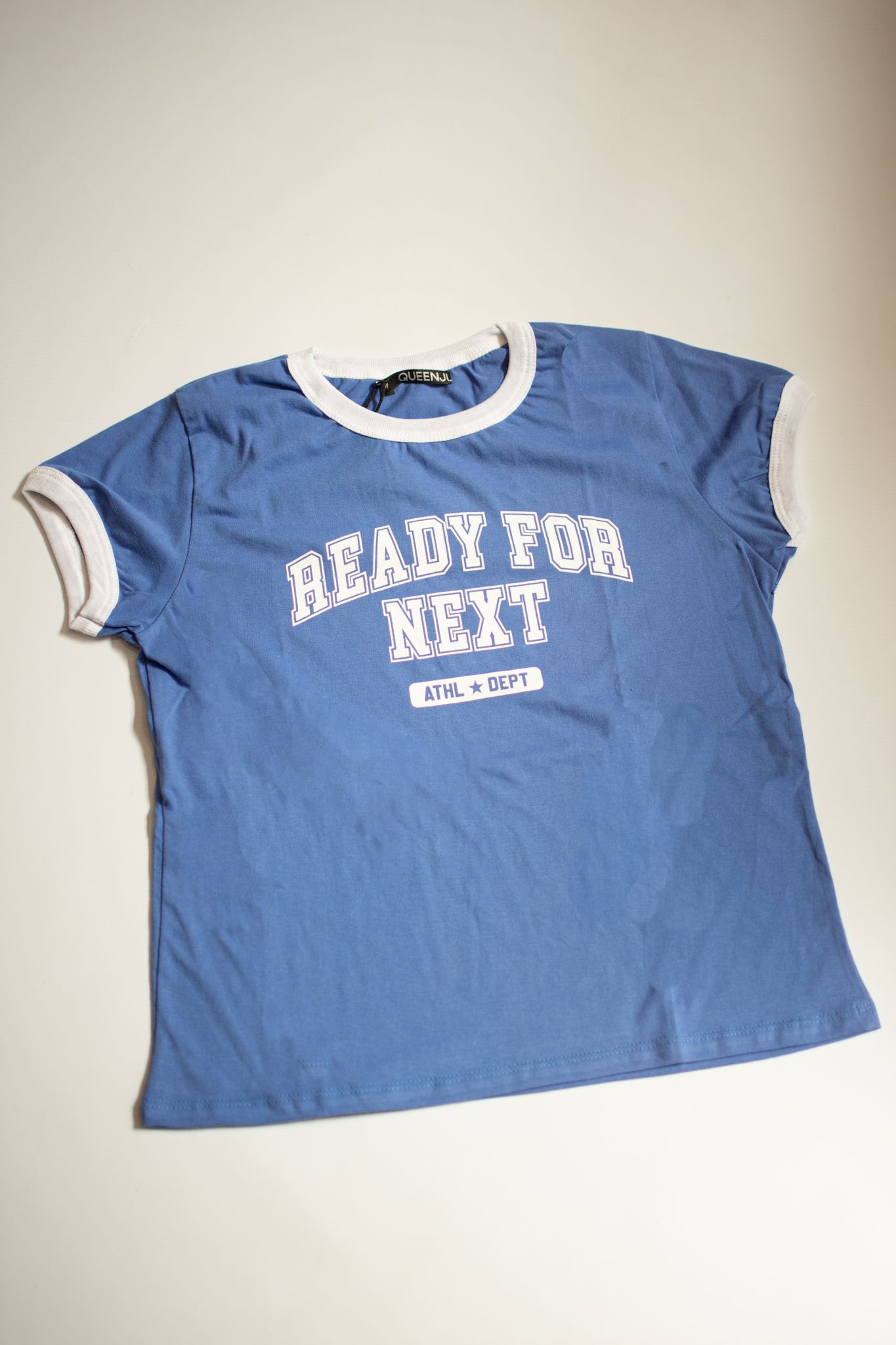 Camiseta azul con ribete blanco y texto 