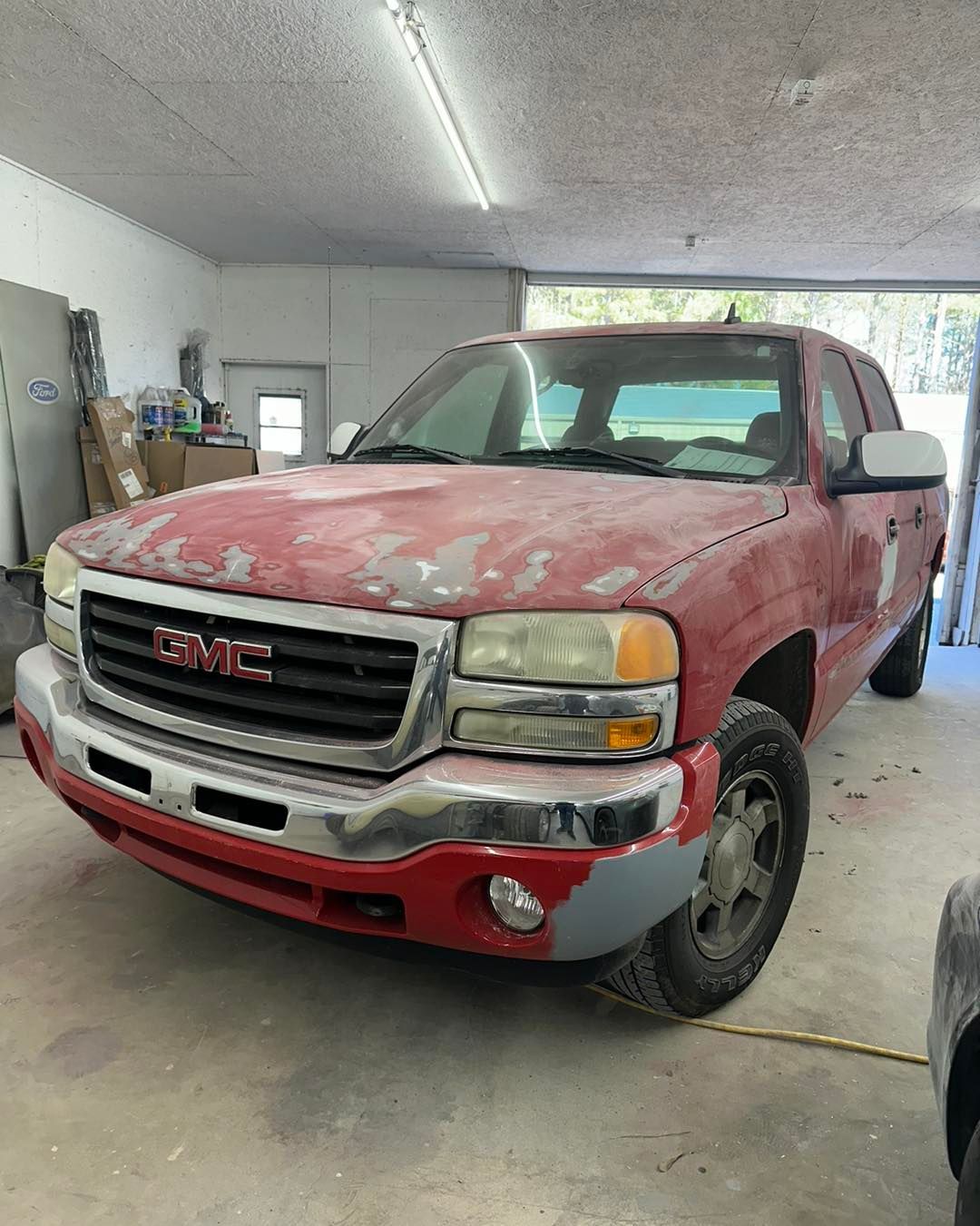 A red gmc truck is parked in a garage.